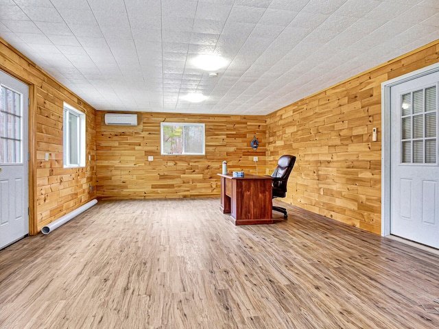 interior space with hardwood / wood-style flooring, wood walls, a healthy amount of sunlight, and a wall mounted air conditioner