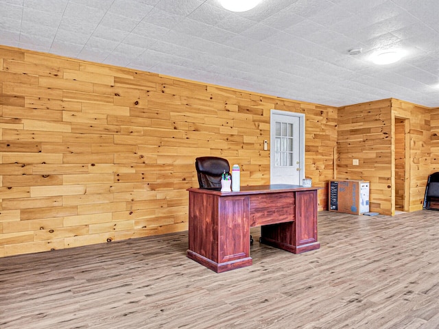 unfurnished office featuring hardwood / wood-style flooring and wooden walls