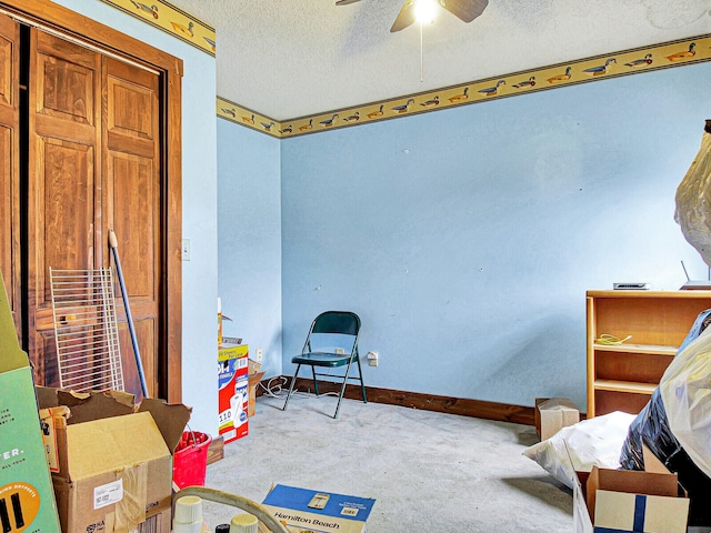 interior space featuring light carpet, ceiling fan, and a textured ceiling