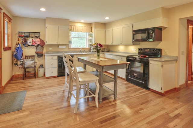 kitchen featuring light hardwood / wood-style flooring, white cabinets, and black appliances