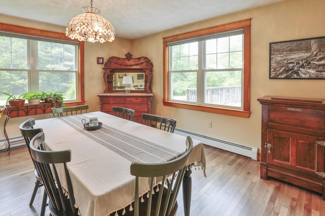 dining room with light hardwood / wood-style floors, a notable chandelier, and a baseboard heating unit