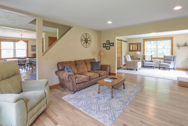 living room featuring a barn door and light hardwood / wood-style floors