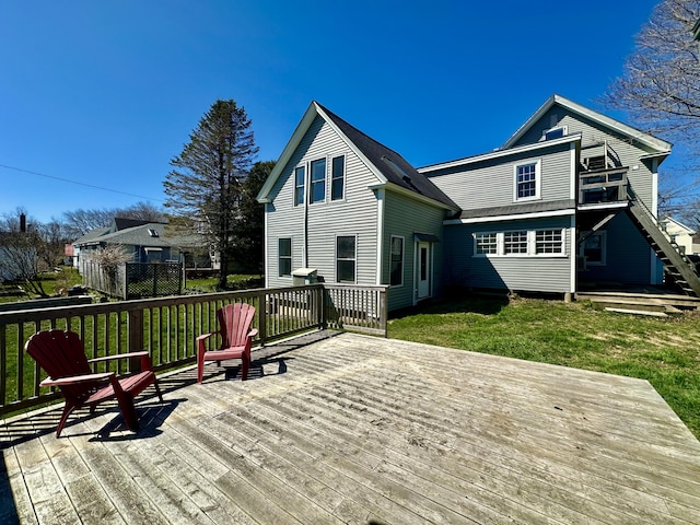 back of house with a deck and a lawn