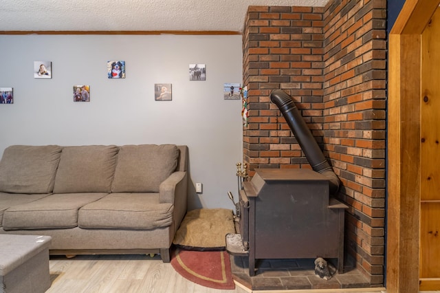 98 Old Rte 1, Gouldsboro, ME 04607 - living room with a textured ceiling, a wood stove, light hardwood / wood-style floors, and crown molding