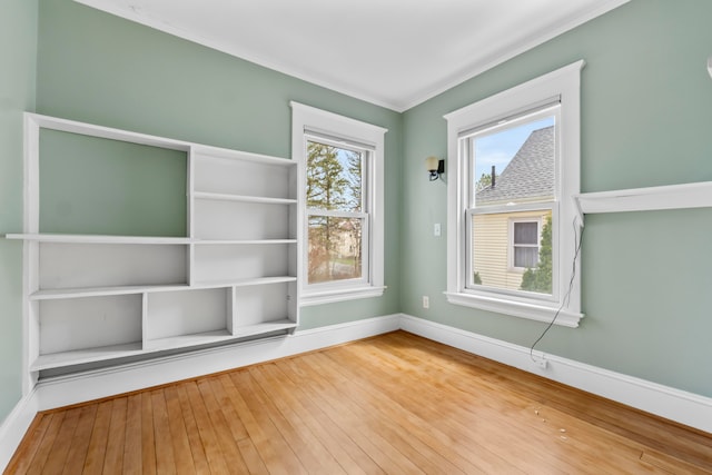 unfurnished room with ornamental molding and hardwood / wood-style floors