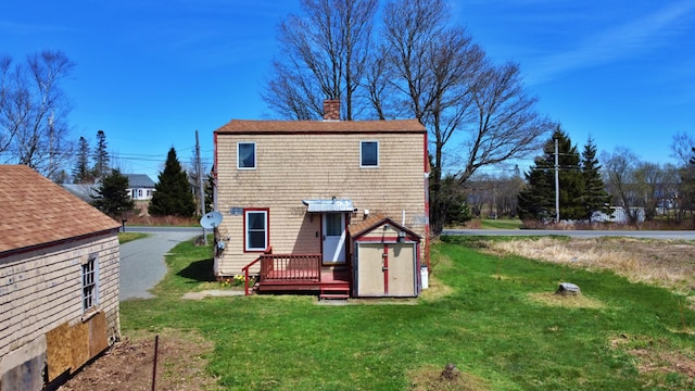 rear view of house featuring a wooden deck and a yard