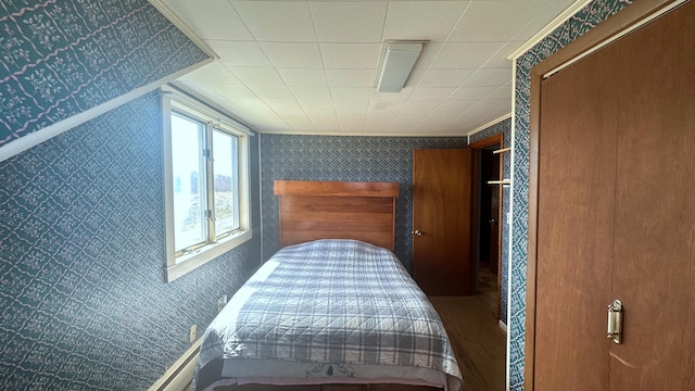 bedroom featuring ornamental molding and wood-type flooring