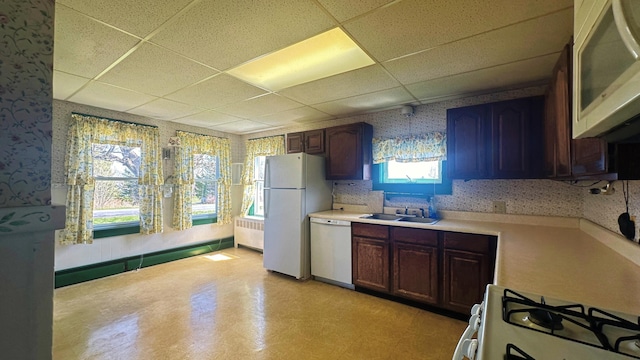 kitchen with a paneled ceiling, radiator heating unit, white appliances, tasteful backsplash, and dark brown cabinets