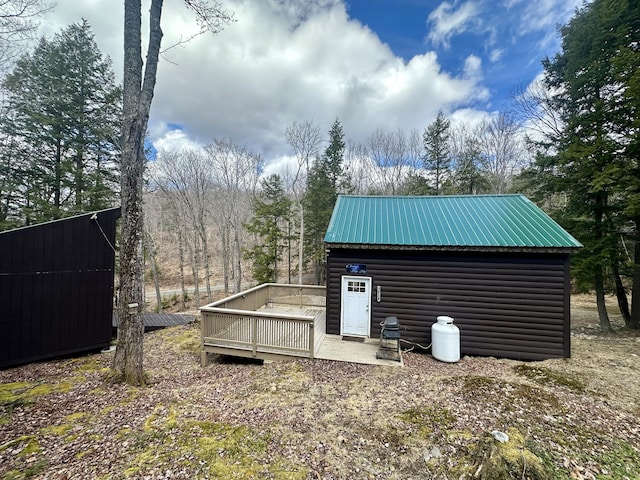 view of home's exterior with an outdoor structure and a wooden deck