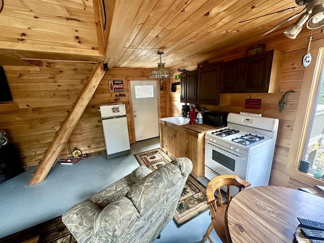 kitchen with wood ceiling, dark brown cabinets, wooden walls, and white appliances