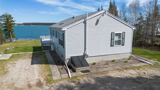 view of property exterior with a yard and a water view