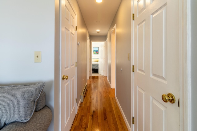 hallway with wood-type flooring and a baseboard radiator