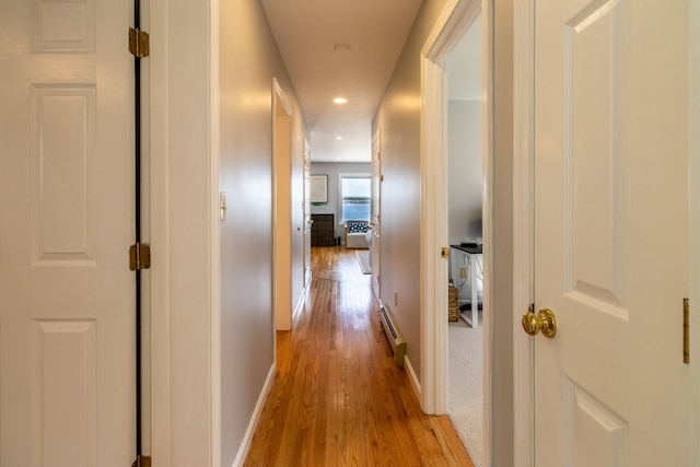 hallway with light hardwood / wood-style floors and baseboard heating