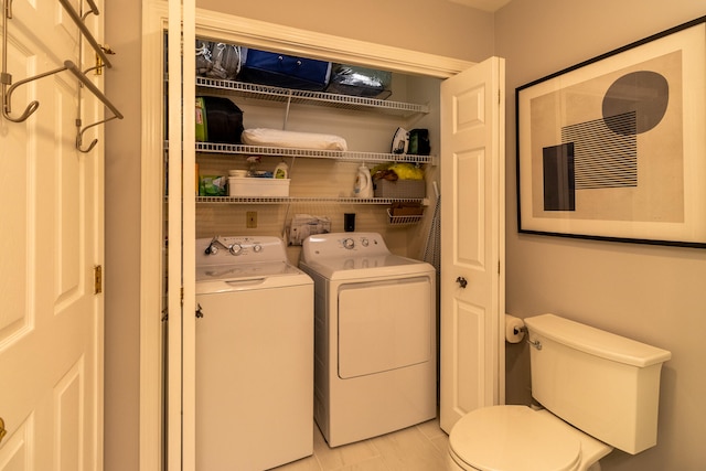 clothes washing area featuring washing machine and dryer and light tile floors