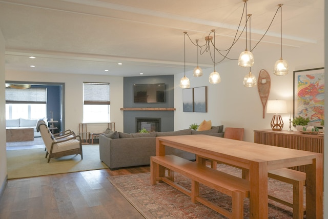 dining space with beam ceiling and hardwood / wood-style flooring