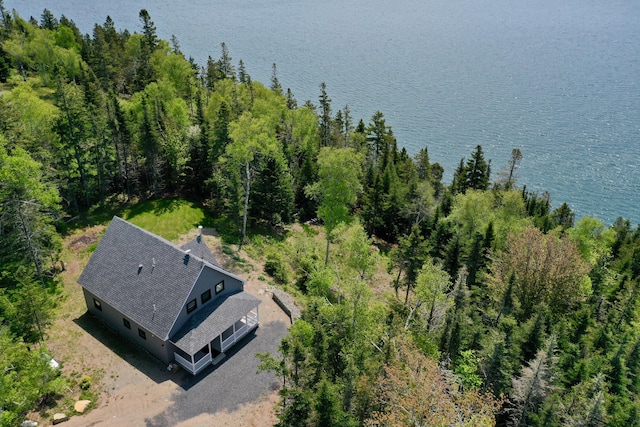 birds eye view of property with a water view and a view of trees