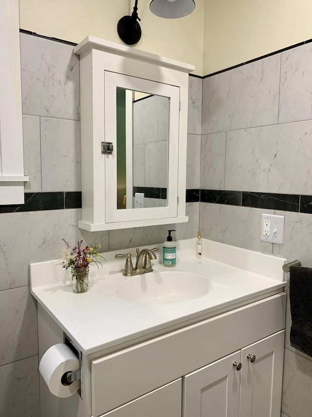 bathroom featuring vanity and tile walls