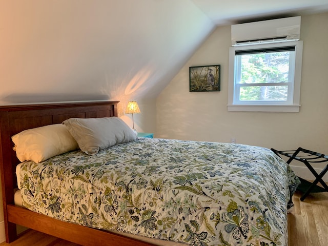 bedroom featuring lofted ceiling, wood finished floors, and a wall mounted AC