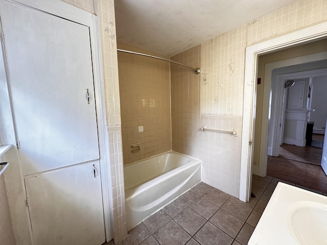 bathroom featuring tiled shower / bath combo, tile floors, and tile walls