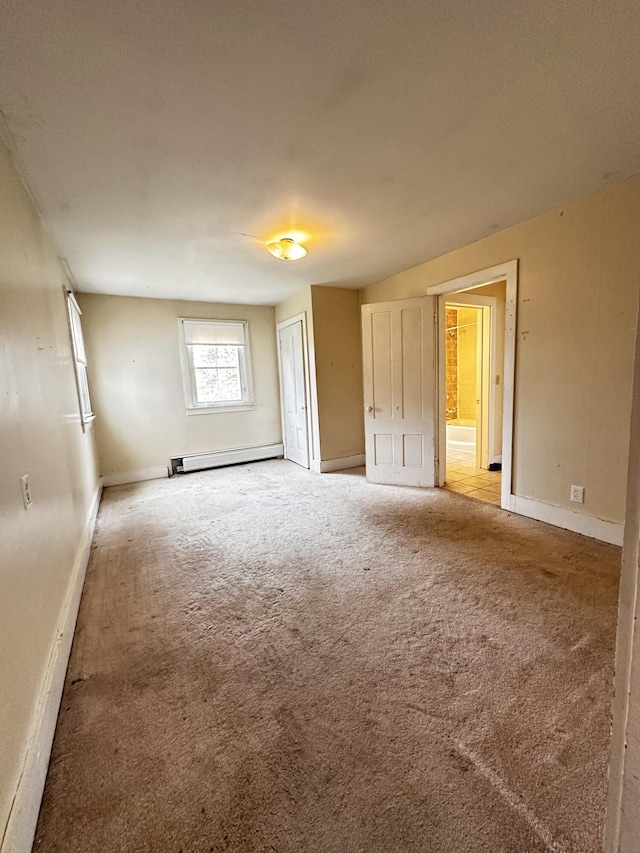 unfurnished bedroom featuring carpet, ensuite bath, and baseboard heating