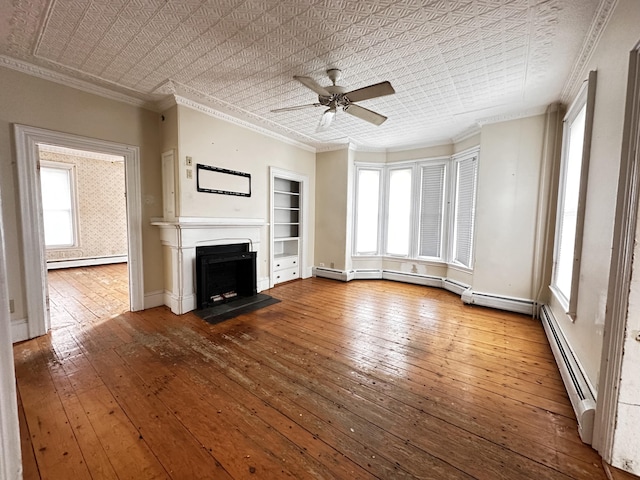 unfurnished living room featuring hardwood / wood-style flooring, crown molding, ceiling fan, and a baseboard radiator