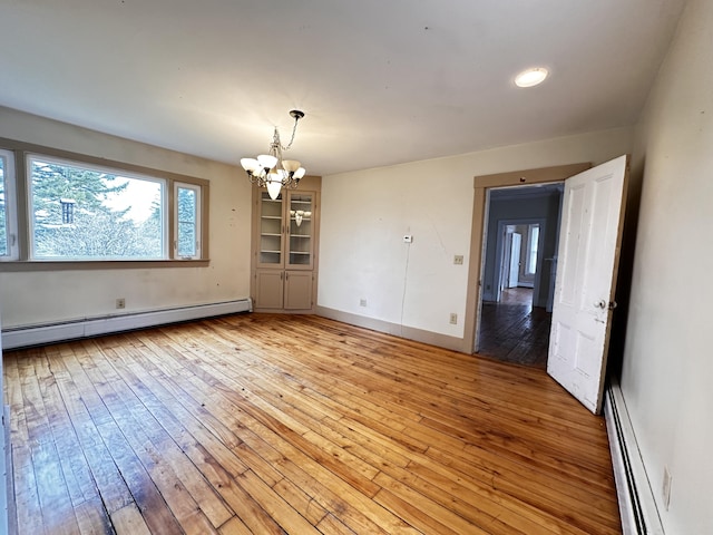 unfurnished room featuring light hardwood / wood-style flooring, a chandelier, and baseboard heating