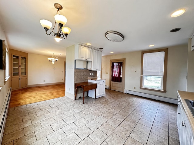 kitchen with backsplash, white cabinetry, light tile floors, and a baseboard radiator