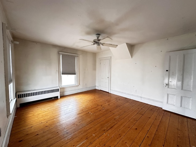 spare room featuring hardwood / wood-style floors, ceiling fan, and radiator