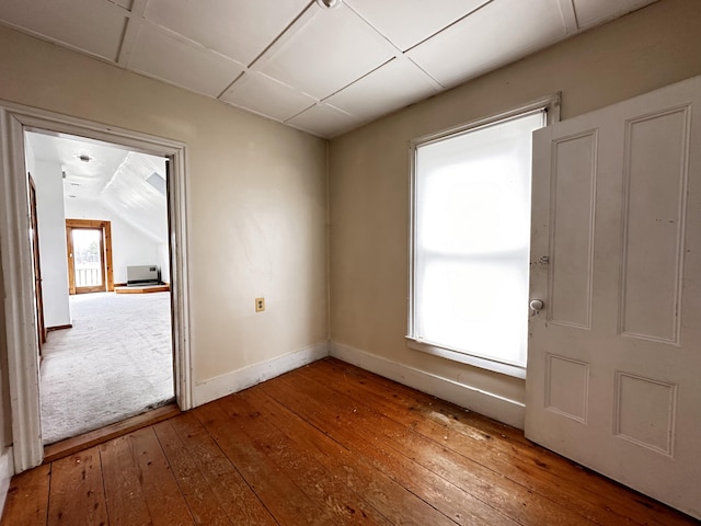 spare room featuring vaulted ceiling and carpet flooring