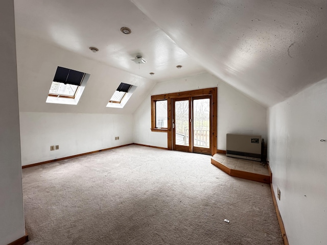 bonus room featuring vaulted ceiling with skylight and carpet flooring