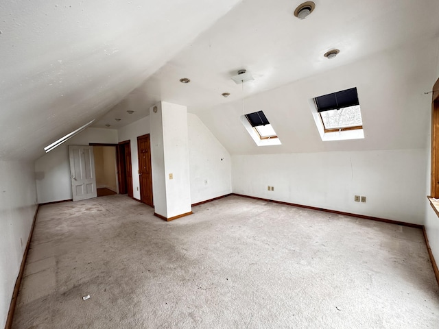 bonus room featuring light carpet and lofted ceiling with skylight