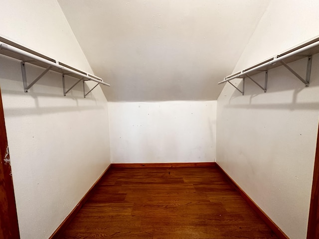 walk in closet featuring hardwood / wood-style floors and lofted ceiling