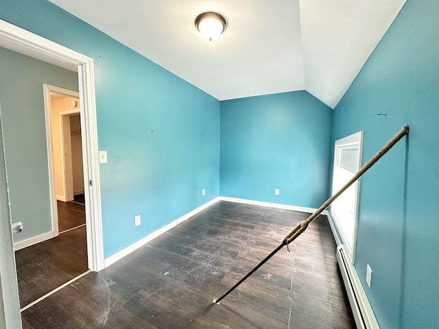 spare room with a baseboard heating unit, dark hardwood / wood-style flooring, and lofted ceiling