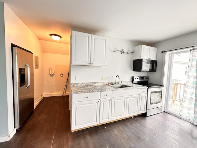 kitchen with sink, white cabinetry, dark hardwood / wood-style flooring, stainless steel appliances, and a wealth of natural light