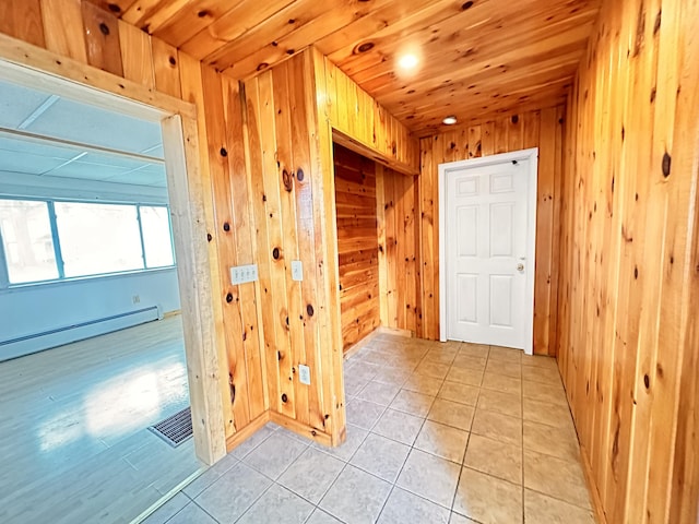 interior space with wooden ceiling, wood walls, light tile floors, and baseboard heating