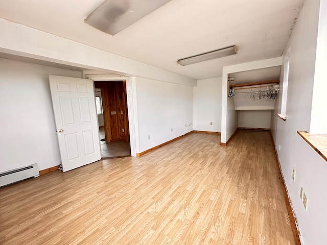 interior space with light wood-type flooring and baseboard heating