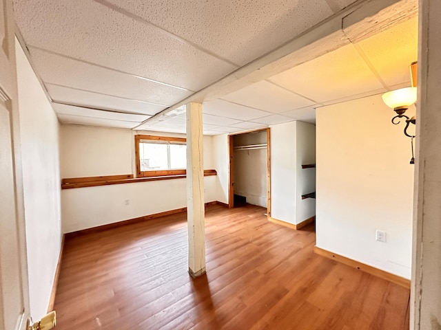 basement featuring hardwood / wood-style flooring and a paneled ceiling