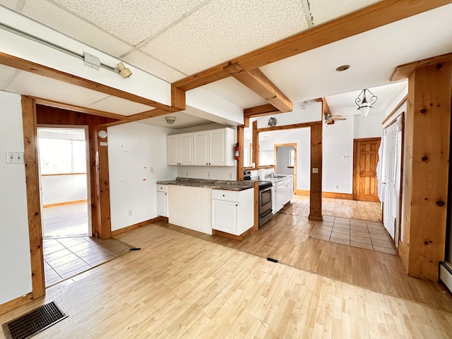 kitchen with stainless steel range with electric stovetop, white cabinetry, a drop ceiling, light tile floors, and ceiling fan