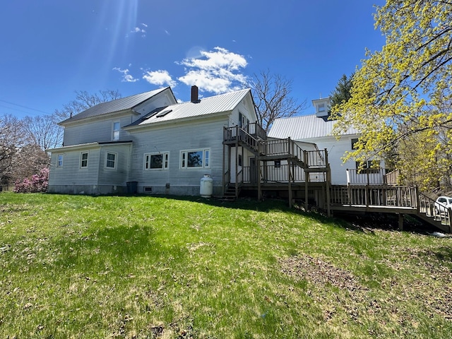 rear view of property with a yard and a wooden deck