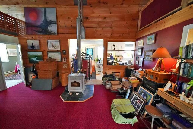242 Crescent Park Rd, New Limerick, ME 04761 - living room featuring a baseboard heating unit and a wood stove
