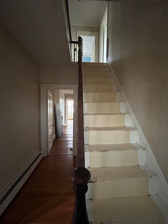 stairway featuring hardwood / wood-style floors and baseboard heating