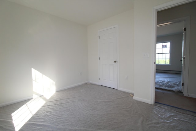 unfurnished bedroom with a baseboard heating unit