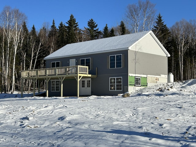 snow covered house featuring a wooden deck