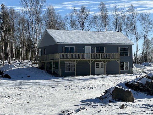 snow covered property with a deck