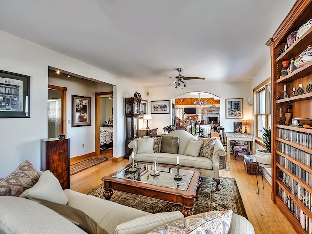 living room with ceiling fan and light wood-type flooring