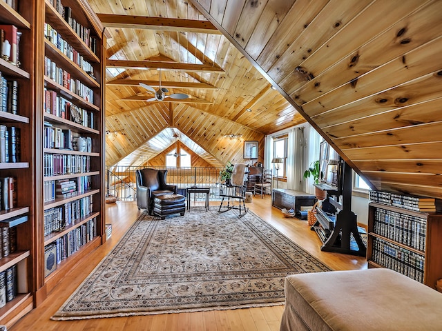 living area featuring vaulted ceiling with beams, light wood-type flooring, ceiling fan, and wood ceiling