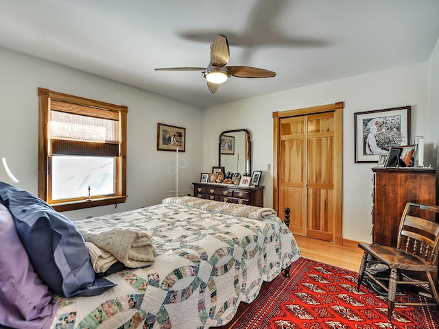 bedroom featuring light wood-type flooring, a closet, and ceiling fan