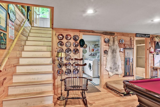 stairway with hardwood / wood-style flooring, washer and dryer, wood walls, and pool table