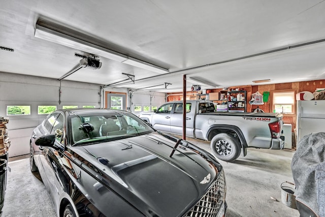 garage featuring a garage door opener and fridge