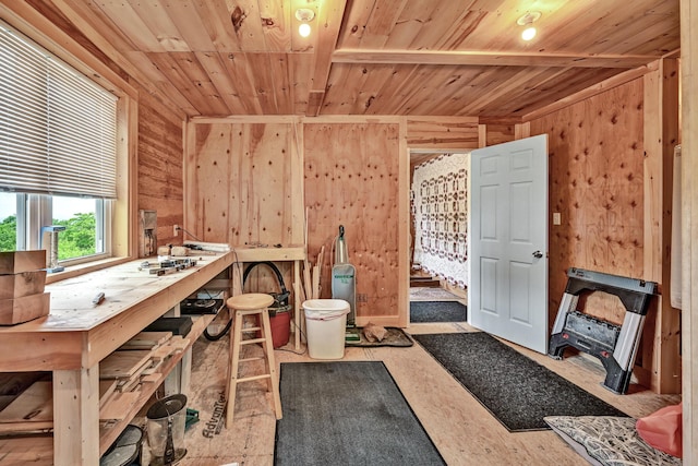 misc room featuring a workshop area, wood walls, and wood ceiling